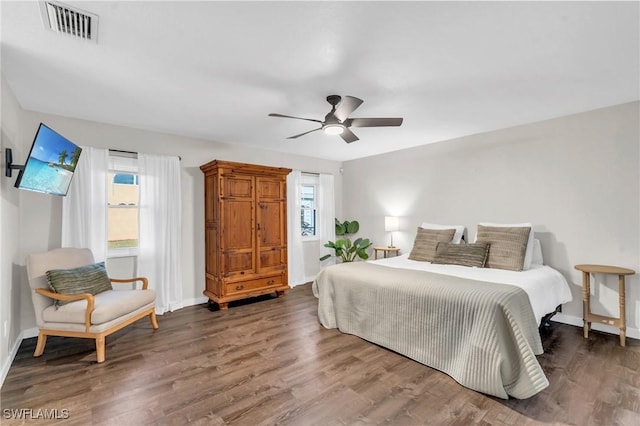 bedroom featuring multiple windows, dark wood-type flooring, and ceiling fan