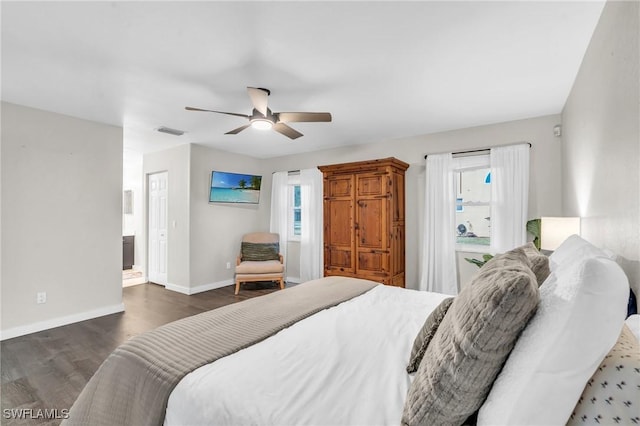 bedroom with ceiling fan, connected bathroom, dark hardwood / wood-style floors, and multiple windows