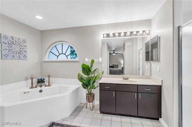 full bath featuring tile patterned flooring, baseboards, a garden tub, ensuite bathroom, and vanity