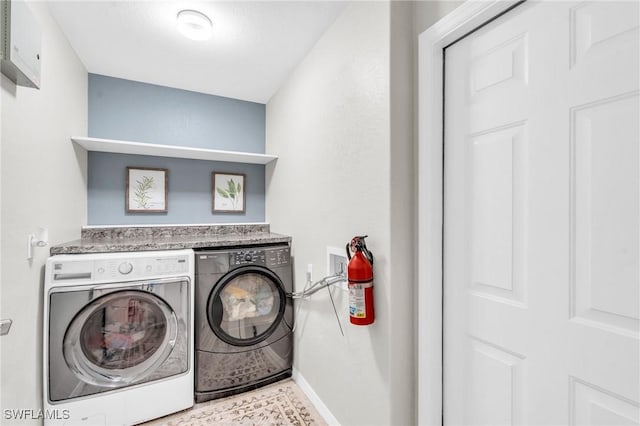 washroom with laundry area, baseboards, and washing machine and clothes dryer