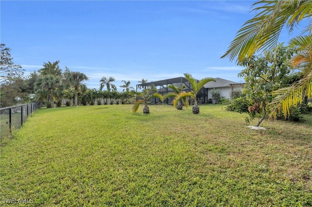 view of yard with a lanai and fence