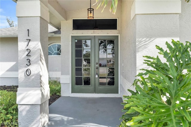 view of exterior entry with french doors and stucco siding