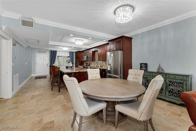 dining space featuring ornamental molding, a notable chandelier, and sink