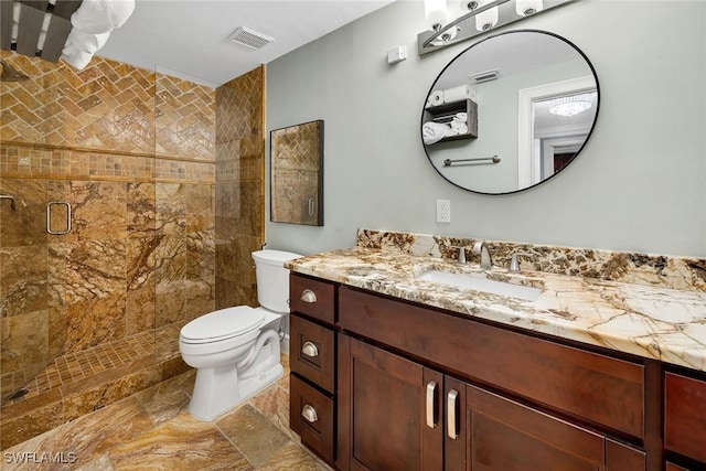 bathroom with vanity, toilet, and a shower with shower door