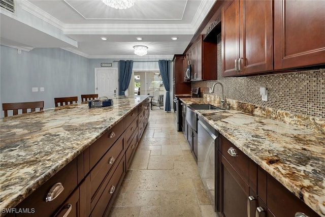 kitchen with light stone counters, a tray ceiling, and an inviting chandelier