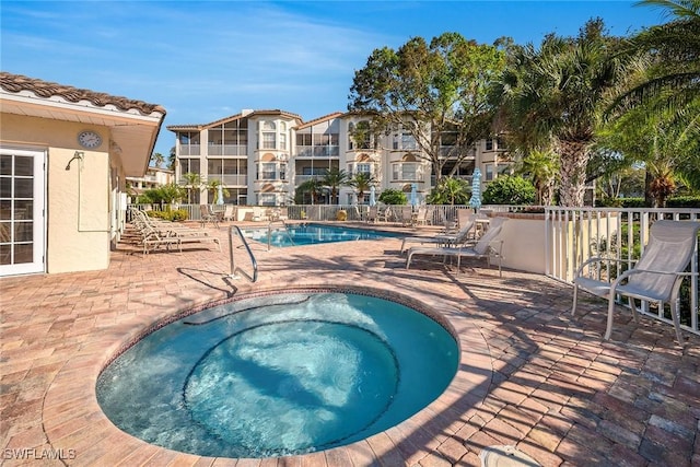 view of swimming pool featuring a community hot tub and a patio