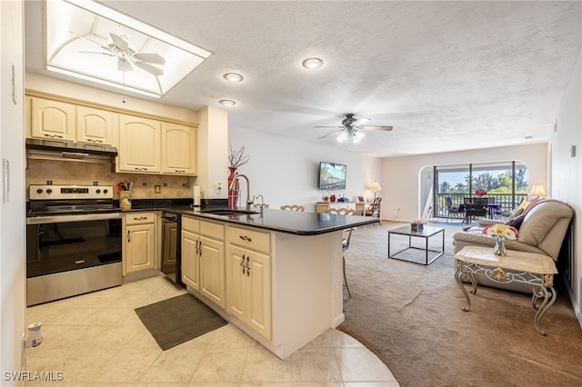 kitchen featuring open floor plan, a peninsula, stainless steel electric stove, under cabinet range hood, and a sink