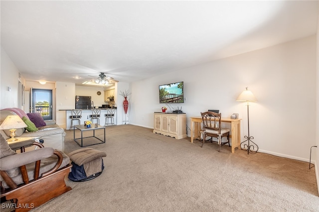 living area featuring ceiling fan, carpet, and baseboards