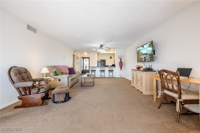 living room with a ceiling fan, light colored carpet, visible vents, and baseboards