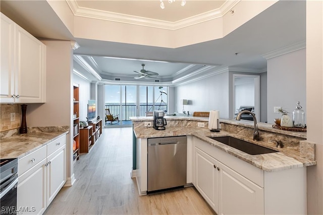 kitchen featuring light wood-type flooring, a sink, crown molding, and stainless steel dishwasher