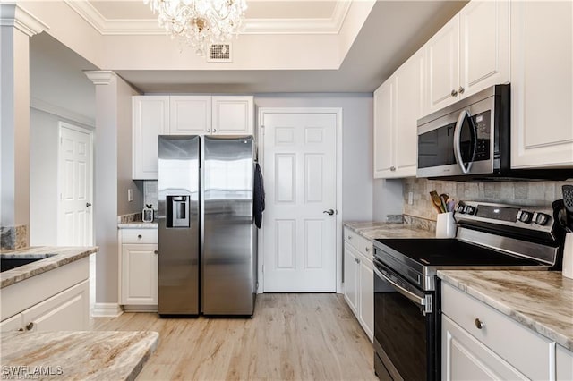 kitchen featuring white cabinets, visible vents, ornamental molding, stainless steel appliances, and light wood-style floors