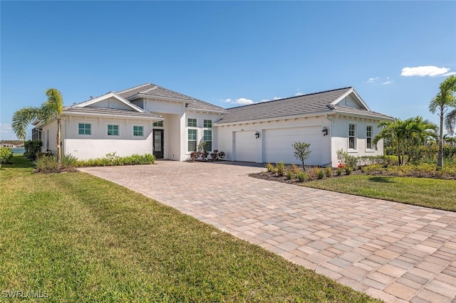 ranch-style home featuring a garage and a front lawn