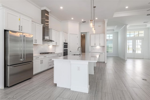 kitchen featuring sink, hanging light fixtures, a center island with sink, white cabinets, and appliances with stainless steel finishes