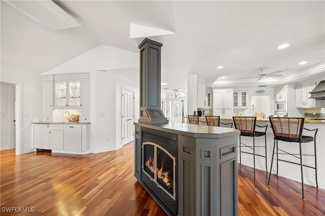 kitchen featuring ceiling fan, stainless steel microwave, sink, hardwood / wood-style floors, and white cabinets