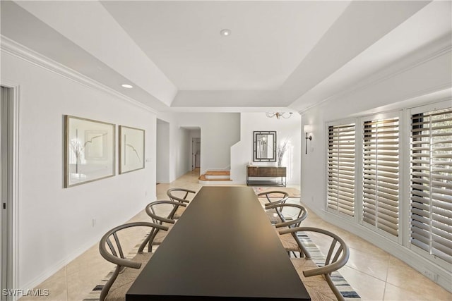 dining space with a raised ceiling and light tile patterned floors