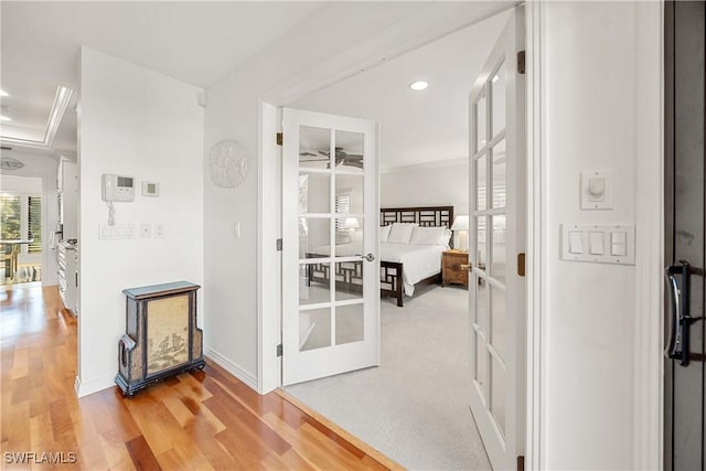 corridor featuring french doors, ornamental molding, and hardwood / wood-style floors