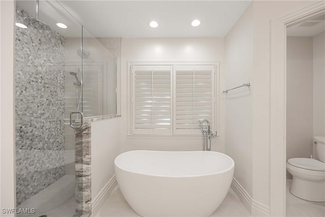 bathroom featuring tile patterned floors, toilet, and shower with separate bathtub