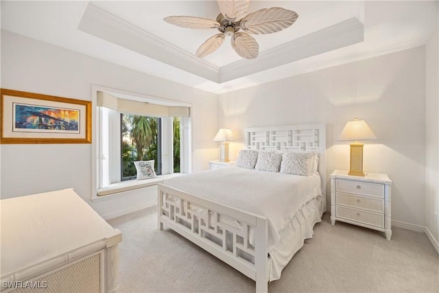 carpeted bedroom with a raised ceiling, ceiling fan, and crown molding