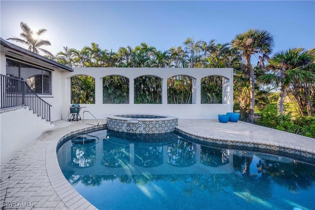 view of pool with an in ground hot tub