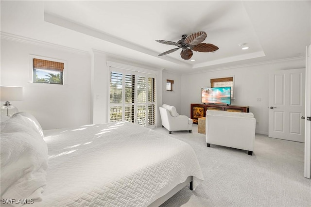 bedroom featuring ornamental molding, access to outside, a tray ceiling, ceiling fan, and light colored carpet