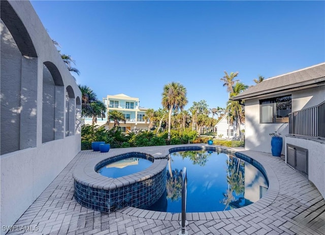 view of pool with an in ground hot tub