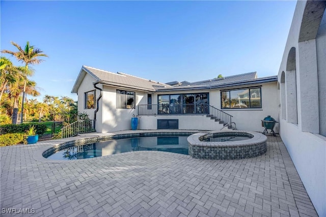 view of swimming pool featuring a patio area and an in ground hot tub