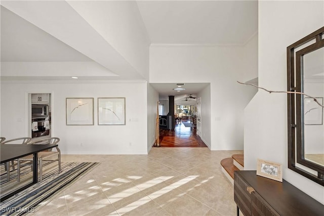 foyer featuring light tile patterned flooring and crown molding