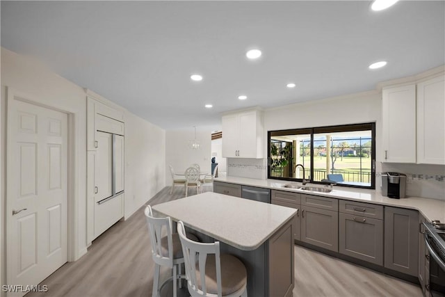 kitchen featuring tasteful backsplash, dishwasher, sink, and white cabinets