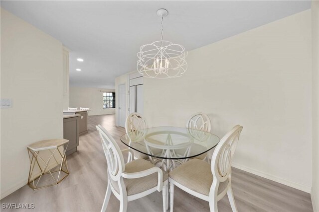 dining area with an inviting chandelier and light wood-type flooring