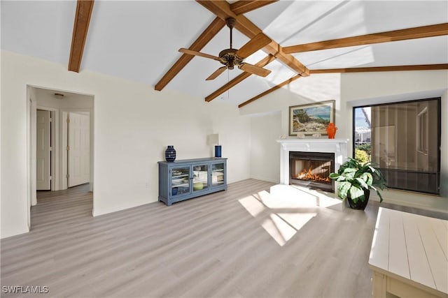 living room featuring vaulted ceiling with beams, ceiling fan, and light hardwood / wood-style flooring