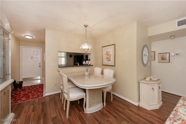 dining space with a chandelier and dark wood-type flooring