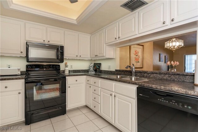 kitchen featuring sink, a tray ceiling, white cabinetry, and black appliances