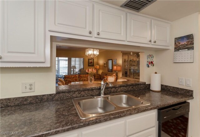 kitchen with dishwasher, white cabinets, an inviting chandelier, and sink