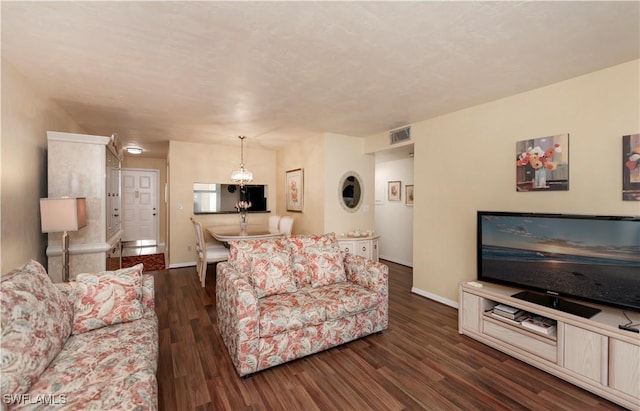 living room featuring dark hardwood / wood-style floors and an inviting chandelier