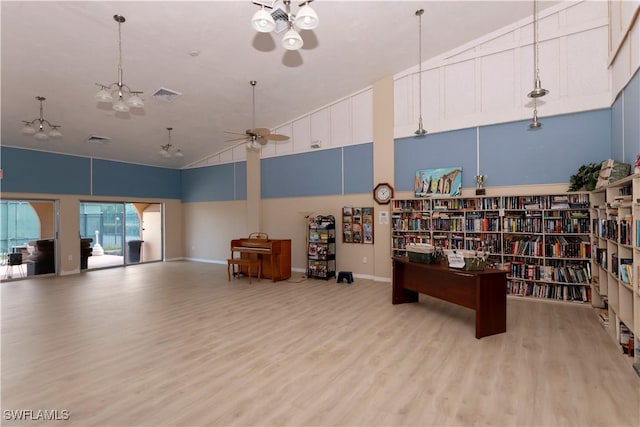 miscellaneous room with ceiling fan, light wood-type flooring, and high vaulted ceiling