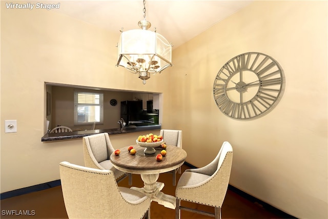 dining space featuring a chandelier and lofted ceiling