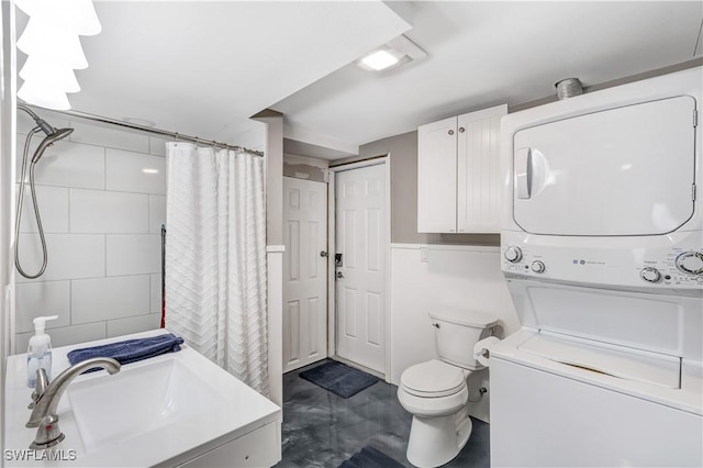 bathroom featuring stacked washing maching and dryer, curtained shower, vanity, and toilet