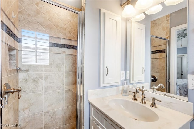 bathroom with a shower with shower door and vanity