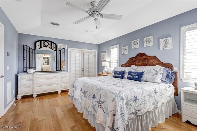 bedroom featuring ceiling fan, light hardwood / wood-style floors, and vaulted ceiling