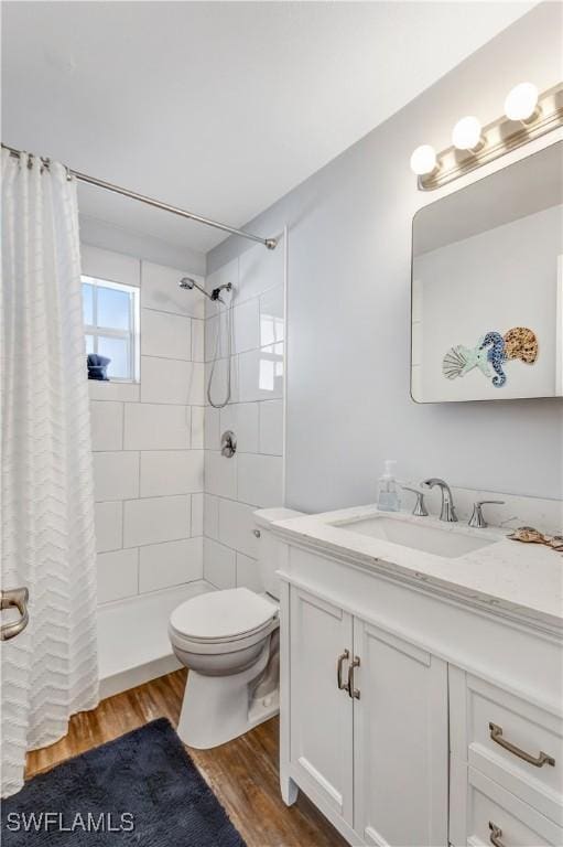 bathroom with a shower with shower curtain, toilet, vanity, and hardwood / wood-style flooring