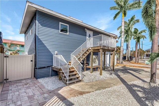 rear view of house with a wooden deck and a patio area