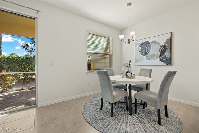 tiled dining room with a notable chandelier