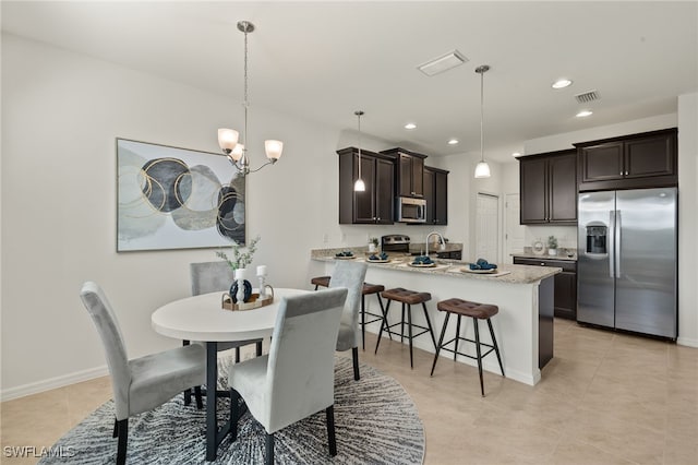 dining room featuring light tile patterned flooring, a chandelier, and sink