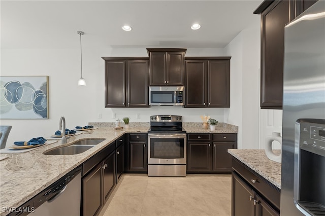 kitchen featuring dark brown cabinetry, sink, hanging light fixtures, light tile patterned floors, and appliances with stainless steel finishes