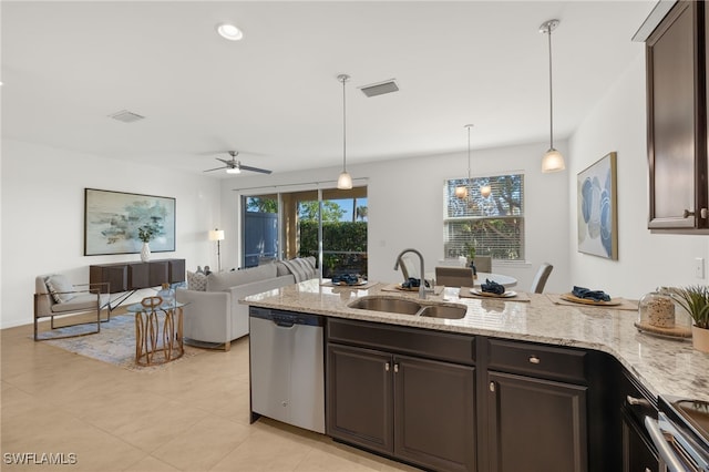 kitchen featuring dark brown cabinetry, sink, light stone counters, hanging light fixtures, and appliances with stainless steel finishes