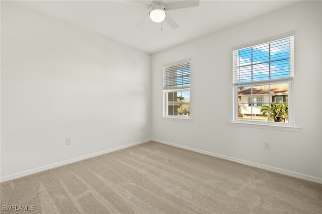 unfurnished room with ceiling fan and light carpet