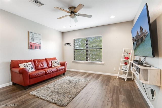 living area featuring ceiling fan, wood finished floors, visible vents, and baseboards