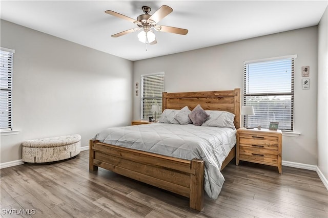 bedroom with ceiling fan, baseboards, and wood finished floors