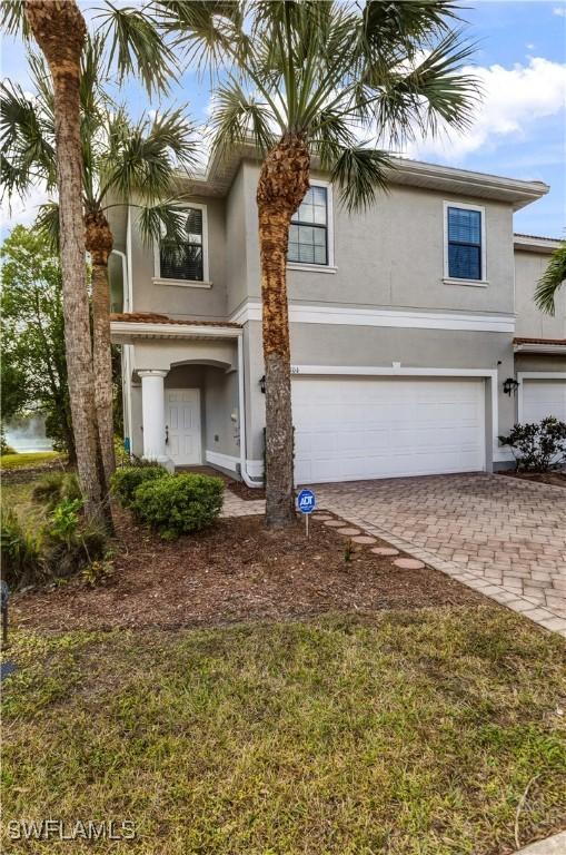 view of front of property with a garage, decorative driveway, and stucco siding