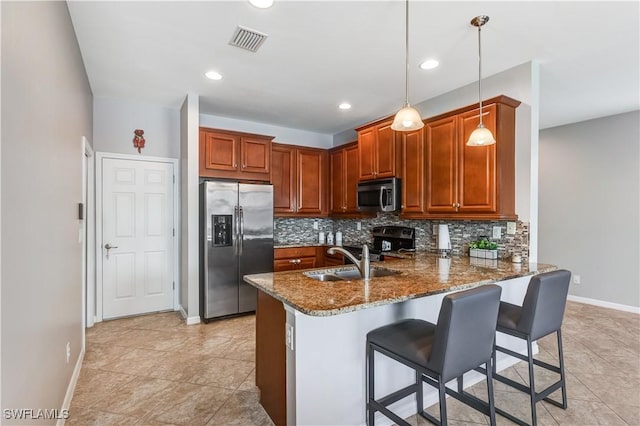 kitchen featuring stainless steel appliances, tasteful backsplash, visible vents, a sink, and a peninsula